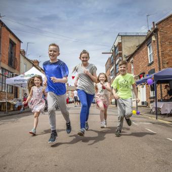 Children running down an open street